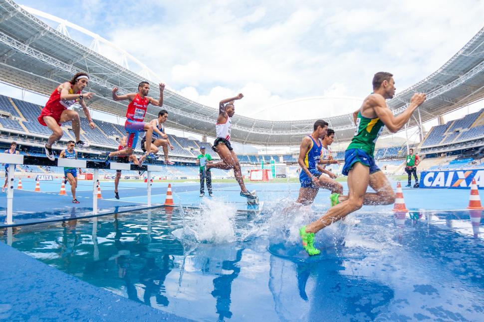 Free Image of Group of Men Running Across Swimming Pool 