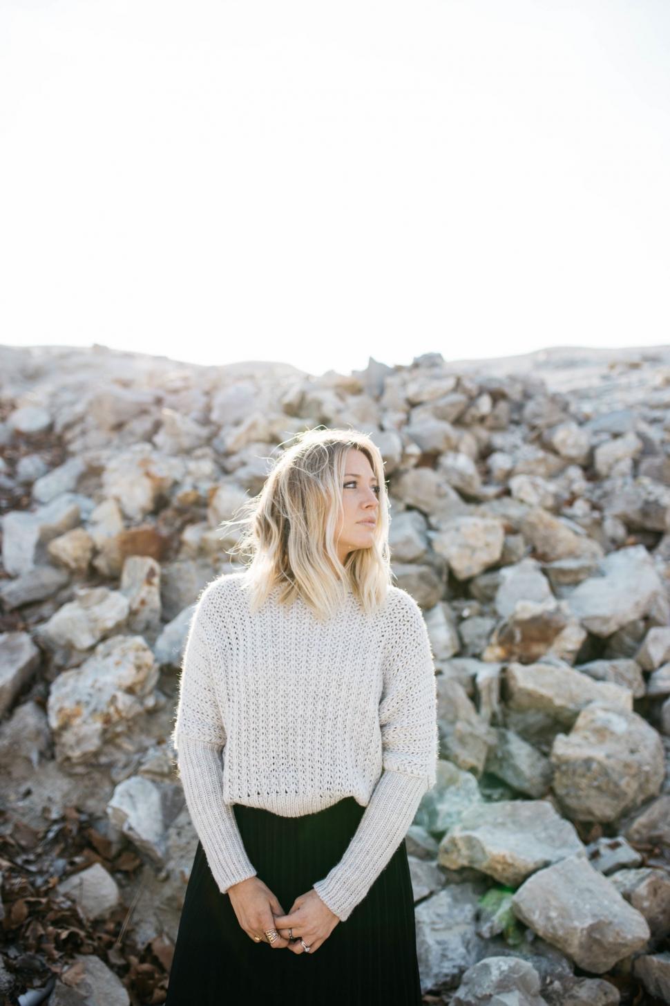Free Image of Woman Standing in Front of Pile of Rocks 