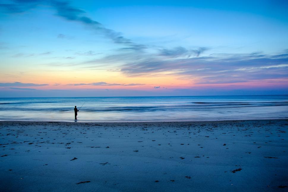 Free Image of Person Standing on Beach at Sunset 