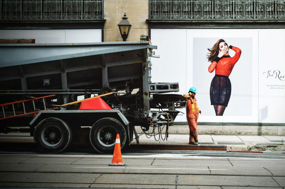 Free Image of Woman Talking on Cell Phone Next to Dump Truck 
