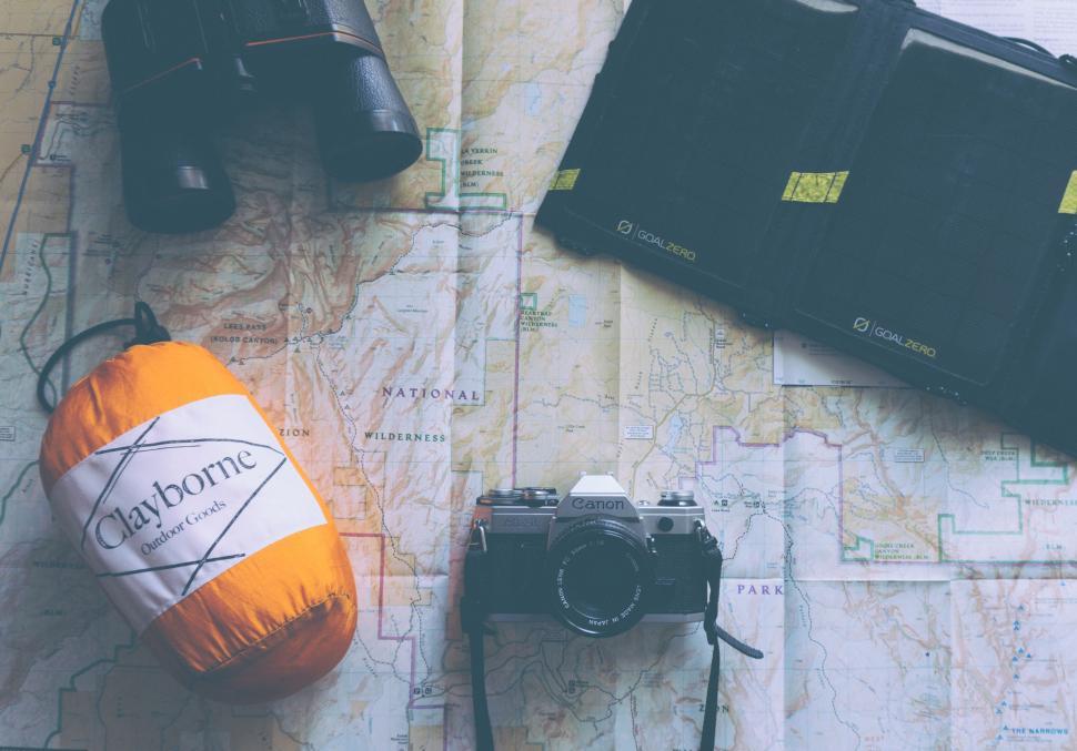 Free Image of Camera, Map, and Various Items on Table 