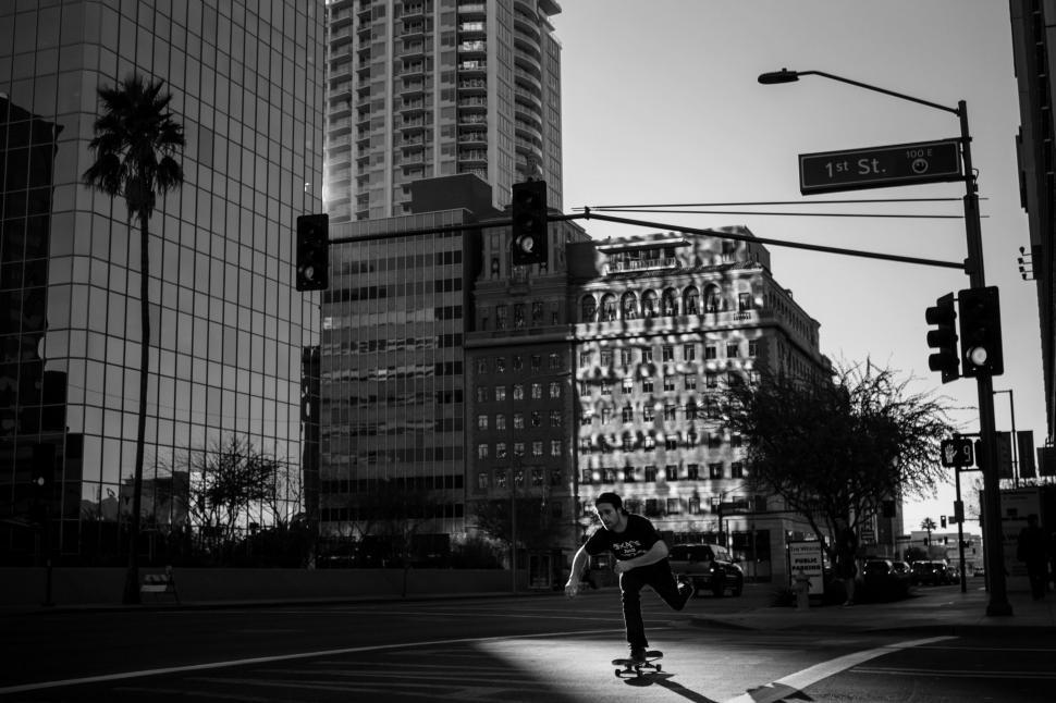 Free Image of Man Skateboarding Down City Street 