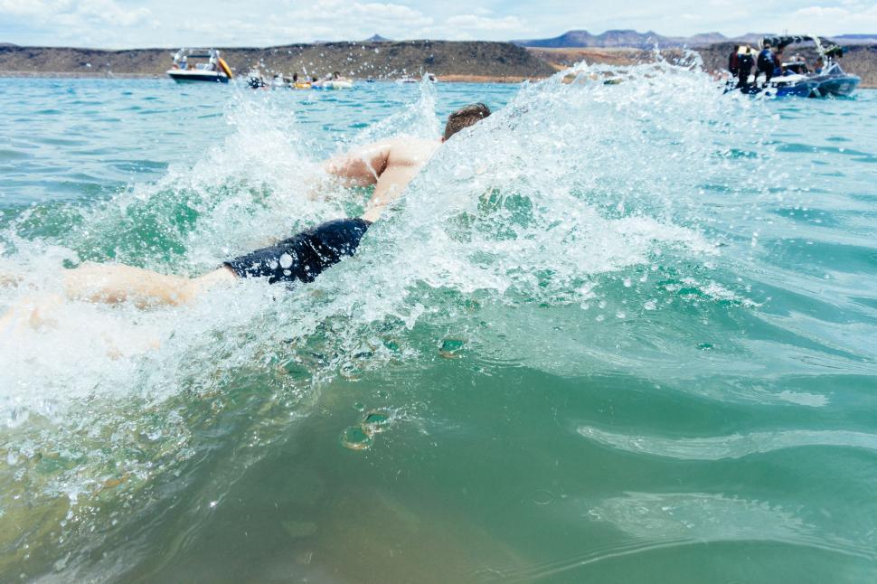 Free Image of Woman Swimming in Ocean With Background People 