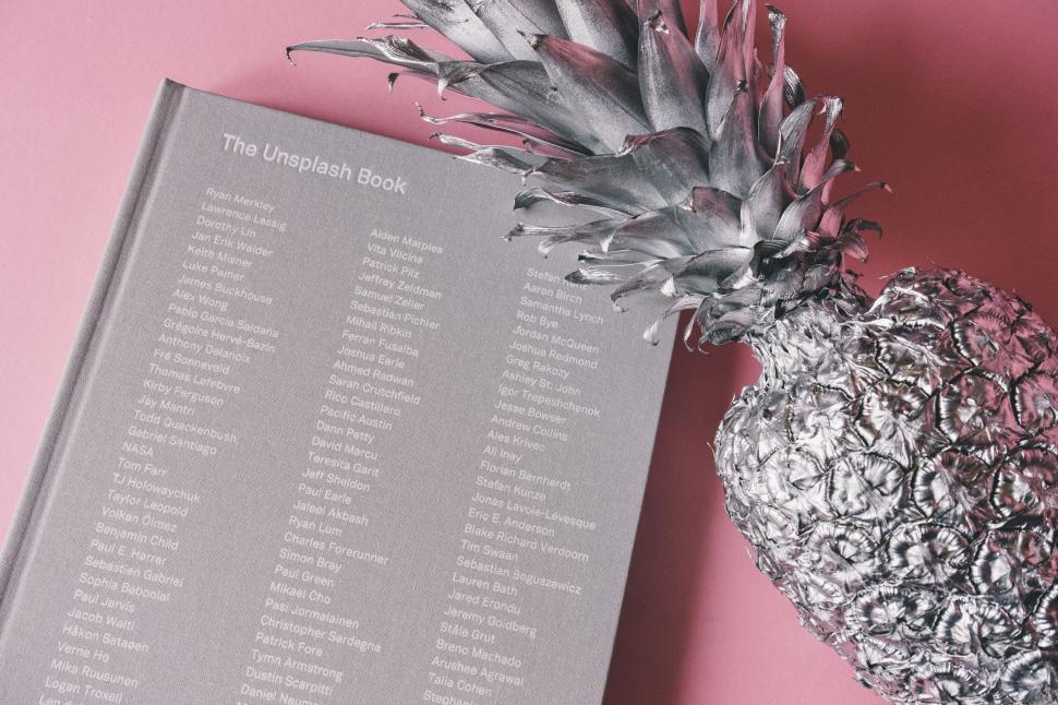 Free Image of Pineapple on Table Next to Book 