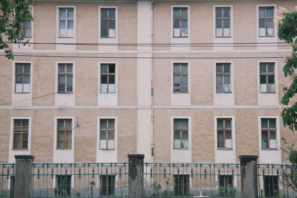 Free Image of Tall Building With Windows Next to Fence 
