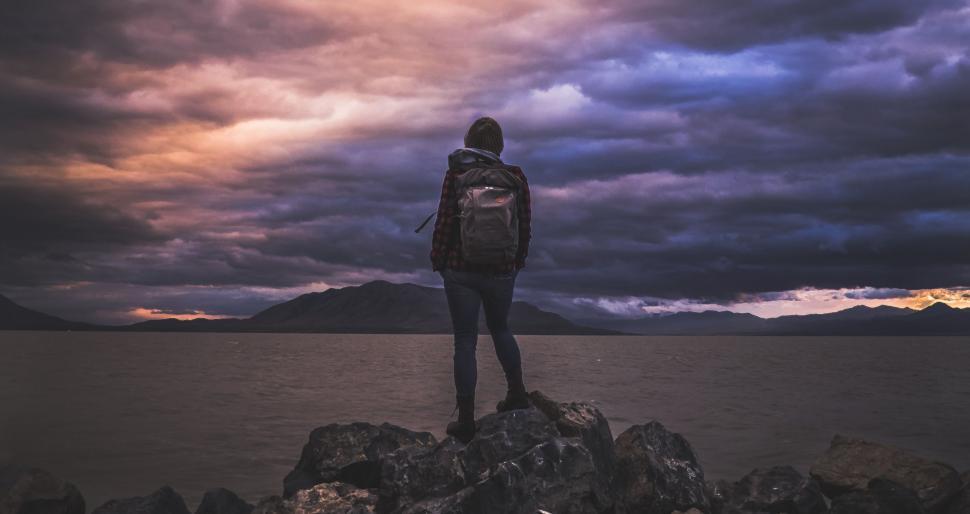 Free Image of Person Standing on Rock Looking Out at Water 
