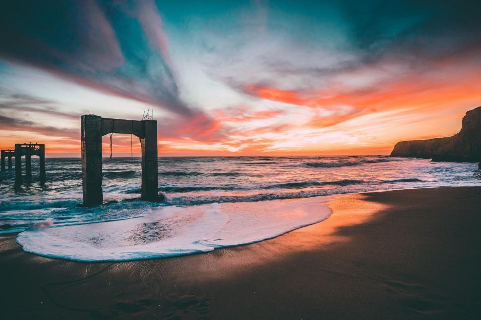 Free Image of Sunset Over Ocean With Pier in Foreground 