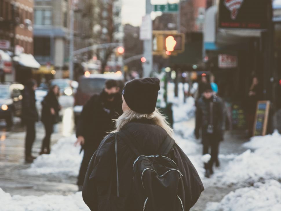 Free Image of Woman Walking Down a Snow Covered Street 