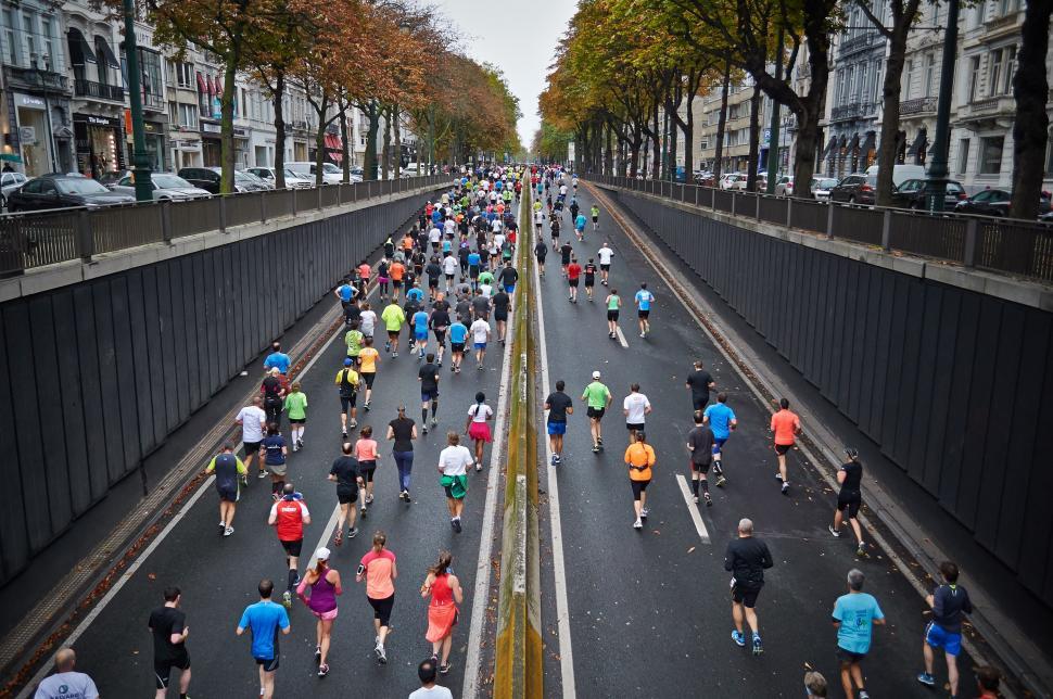 Free Image of Large Group of People Running Down a Street 