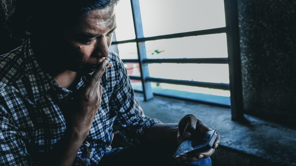 cigarette in dark room Free Stock Photo of Man Smoking a Cigarette in a Dark Room