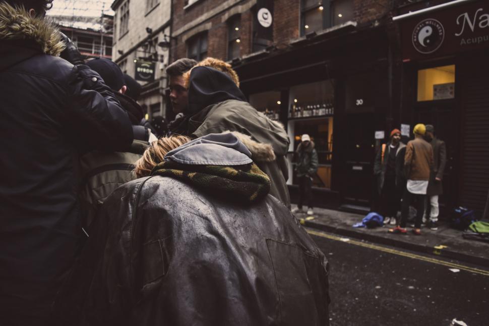 Free Image of Group of People Walking Down a City Street Near Tall Buildings 