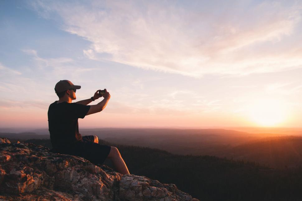 Free Image of Man Sitting on Top of Rocky Cliff 