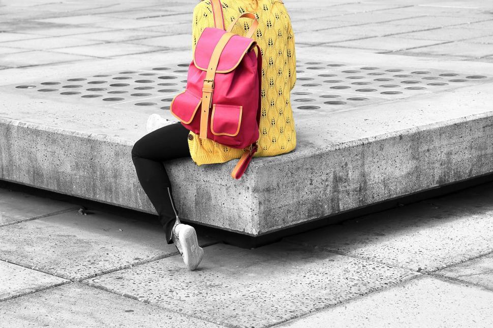 Free Image of Woman Sitting on Bench With Backpack 