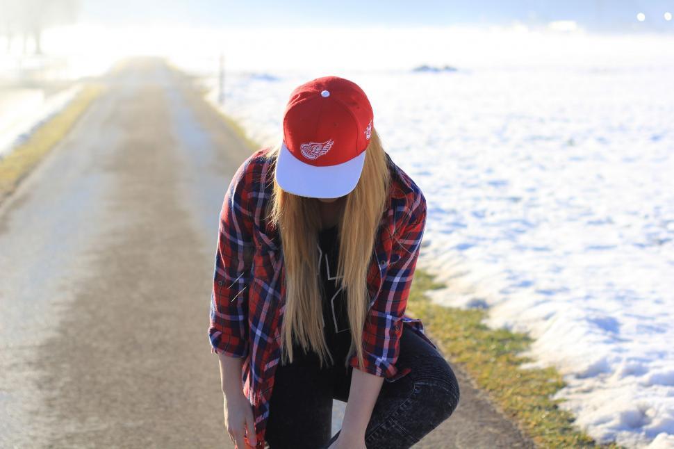 Free Image of Woman Kneeling Down on Road With Skateboard 