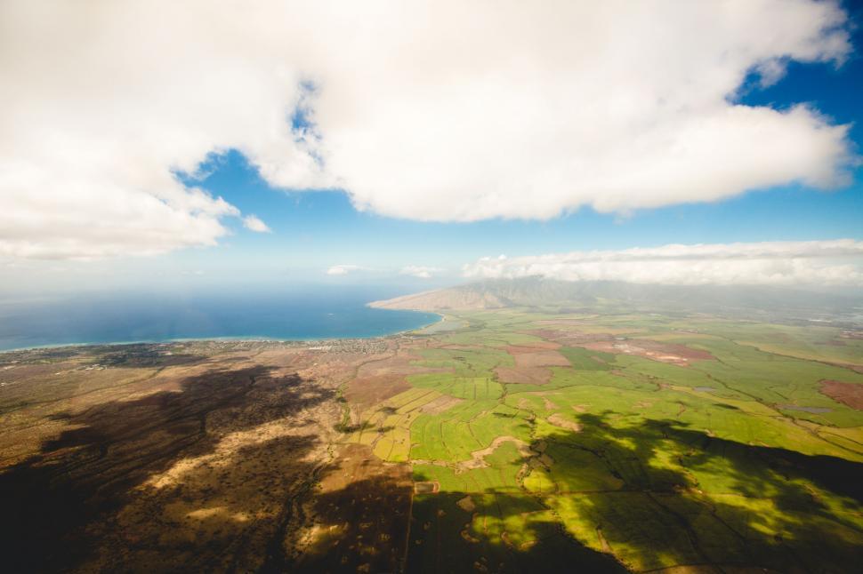 Free Image of Aerial View of Grassland With Distant Body of Water 