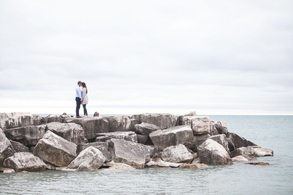 Free Image of Couple Standing on Top of Rock Formation 