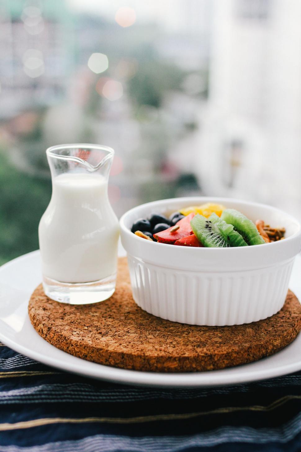 Free Image of A Bowl of Fruit and a Glass of Milk 