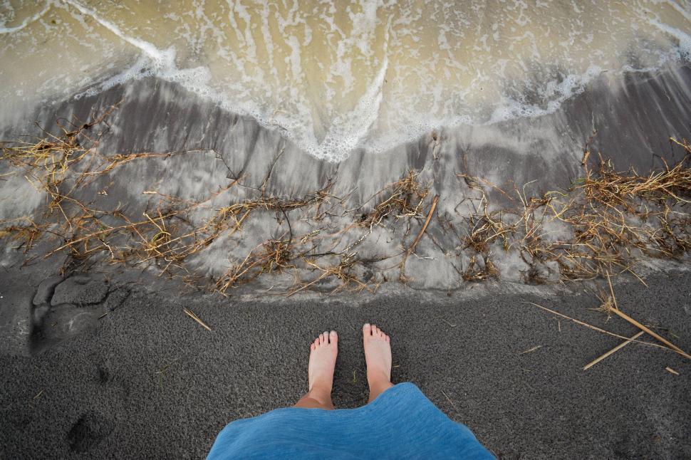 Free Image of Person Standing on Beach Next to Ocean 