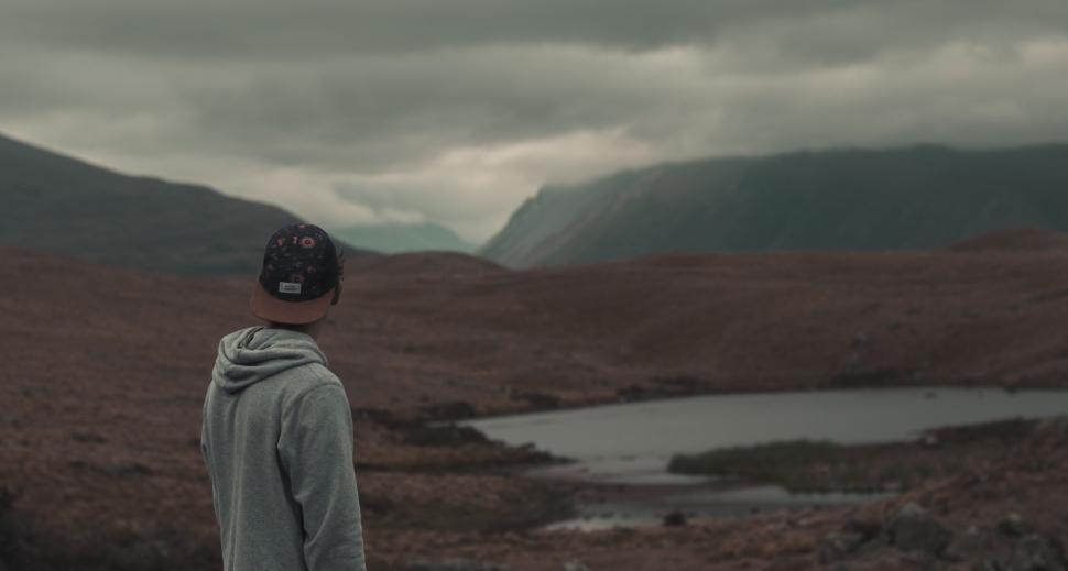 Free Image of Person Standing in Field With Mountains in Background 