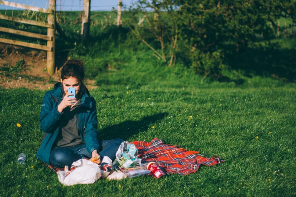 Free Image of Person Sitting on Grass With Cell Phone 