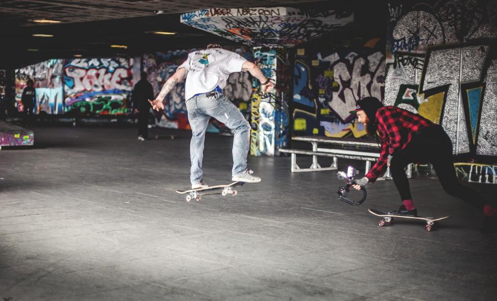Free Image of Two Men Riding Skateboards Together 