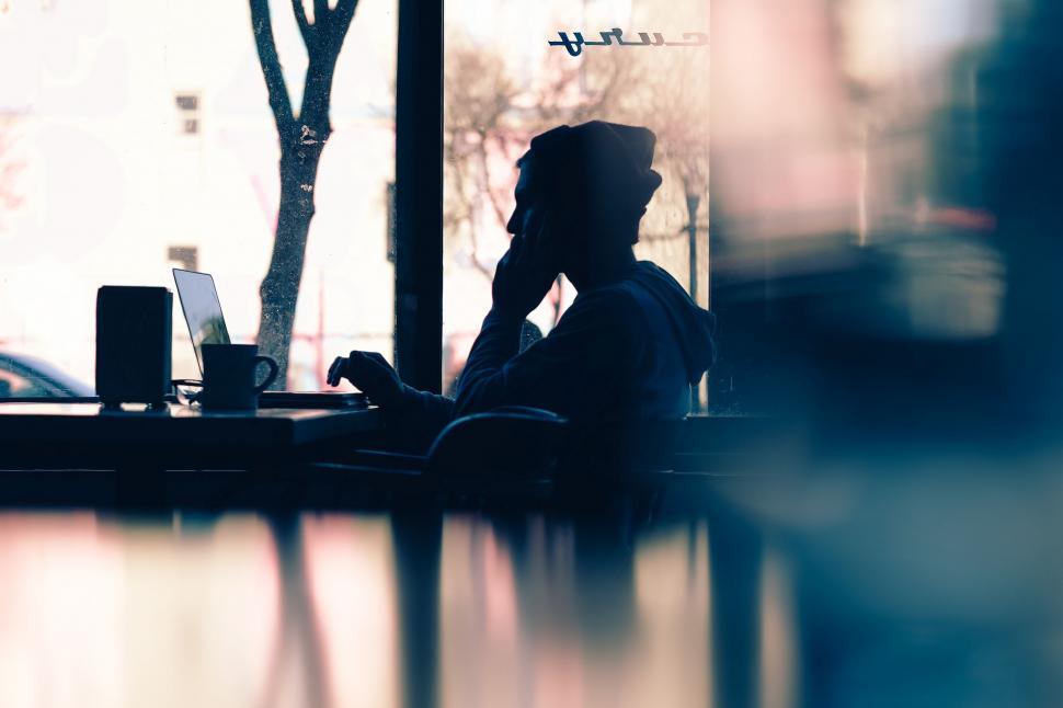 Free Image of Person Sitting at Table by Window 