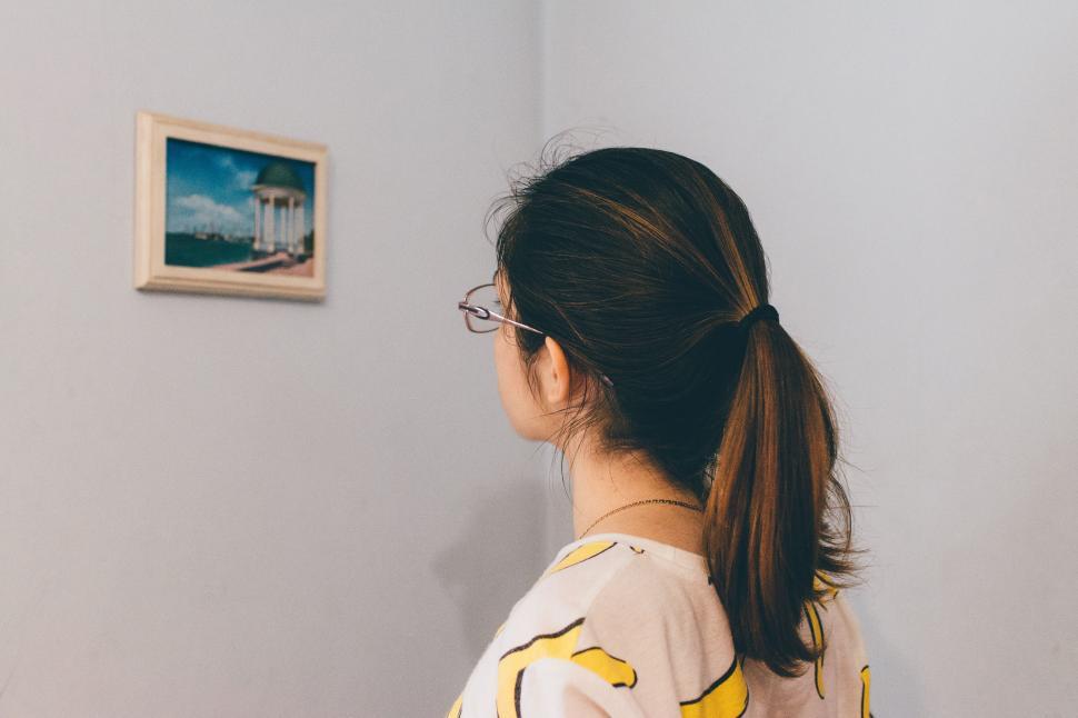 Free Image of Woman Standing in Front of Lighthouse Painting 