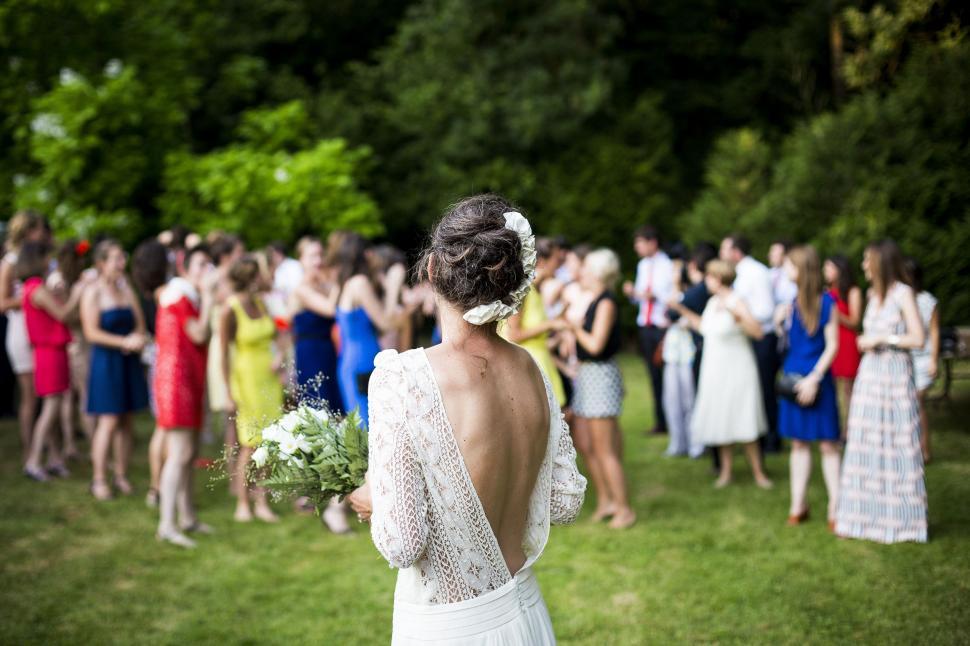 Free Image of Woman in White Dress Standing With Group of People 