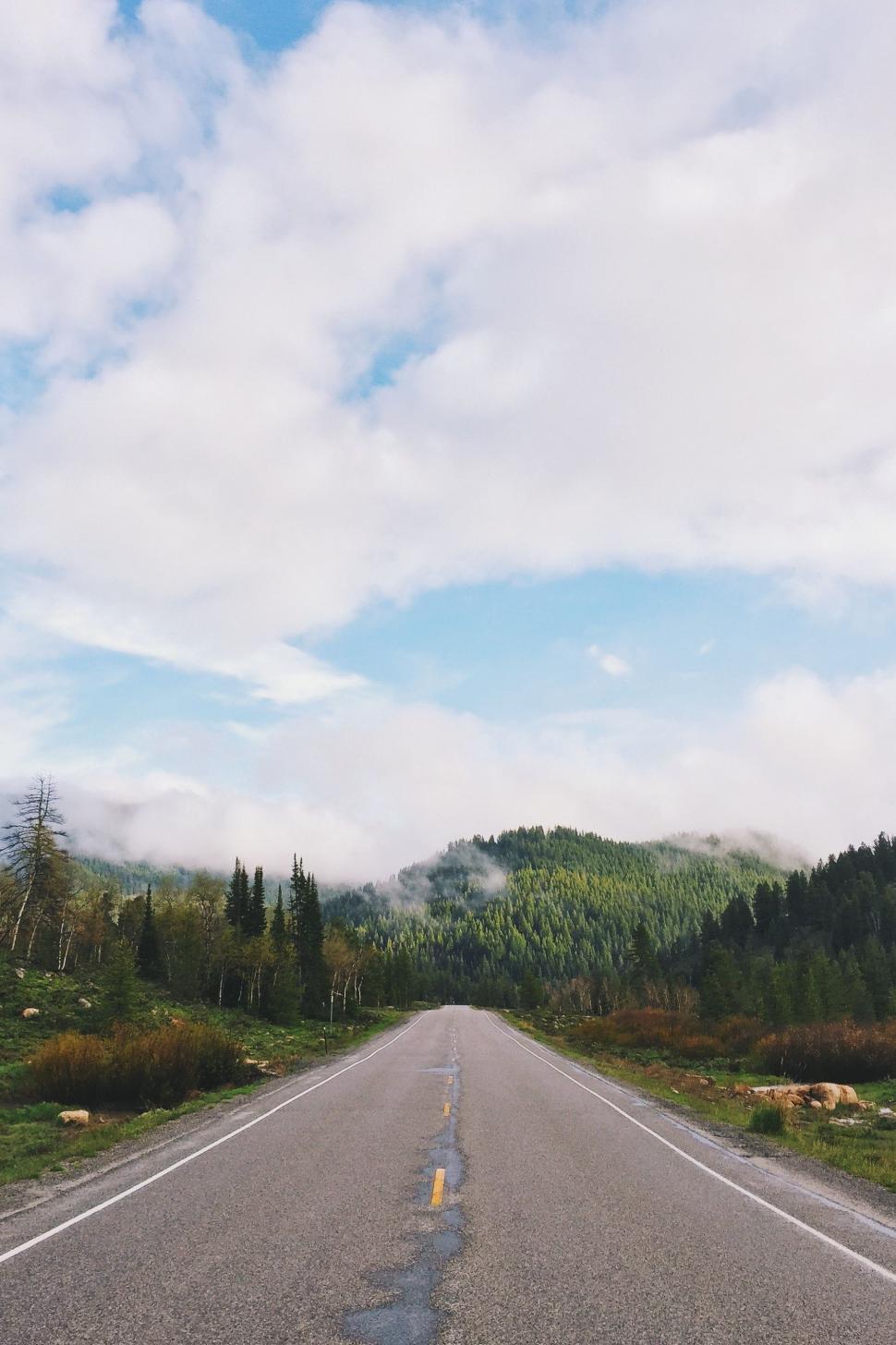 Free Image of Long Empty Road With Trees and Mountains 