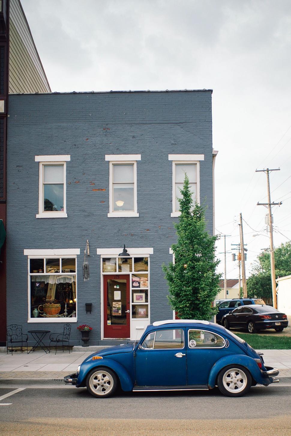 Free Image of Small Blue Car Parked in Front of Building 