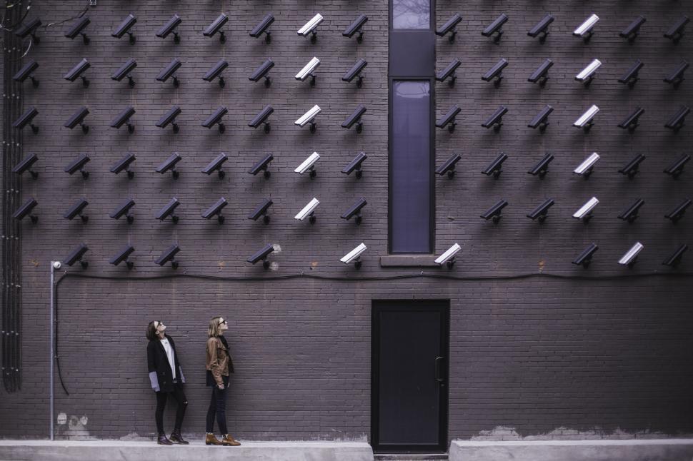 Free Image of Two Men Standing Next to Each Other in Front of a Wall 