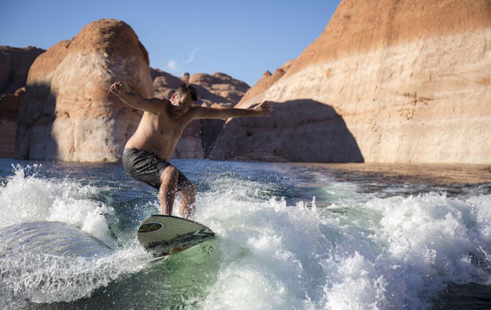 Free Image of Man Riding Wave on Surfboard 