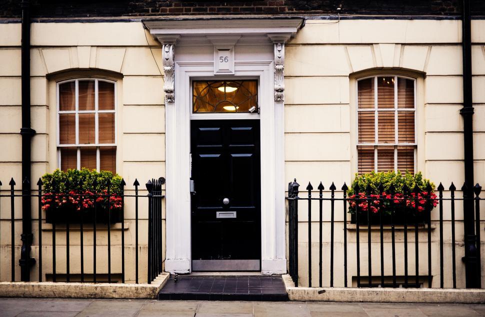 Free Image of White Building With Black Door and Fence 