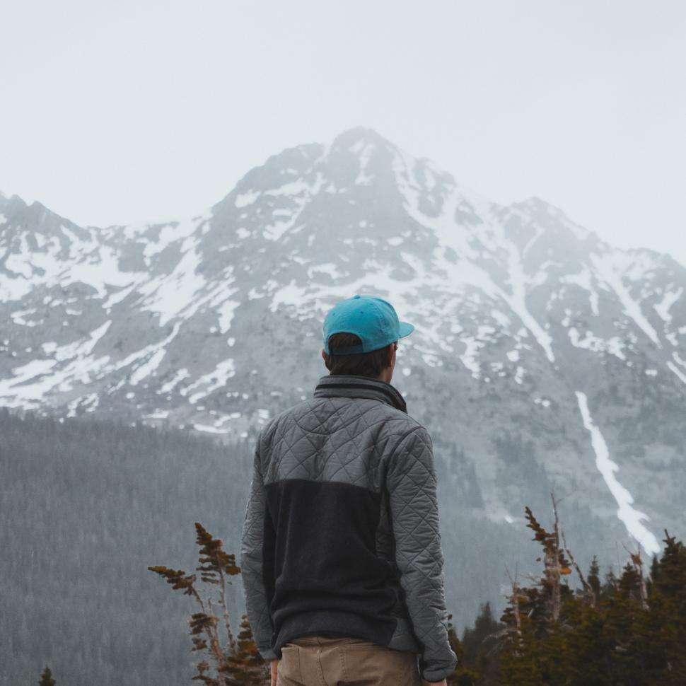 Free Image of Man Standing on Snow Covered Mountain Top 