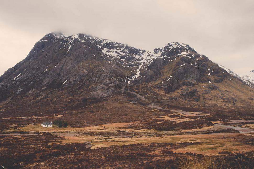 Free Image of Mountain Range With House in Foreground 