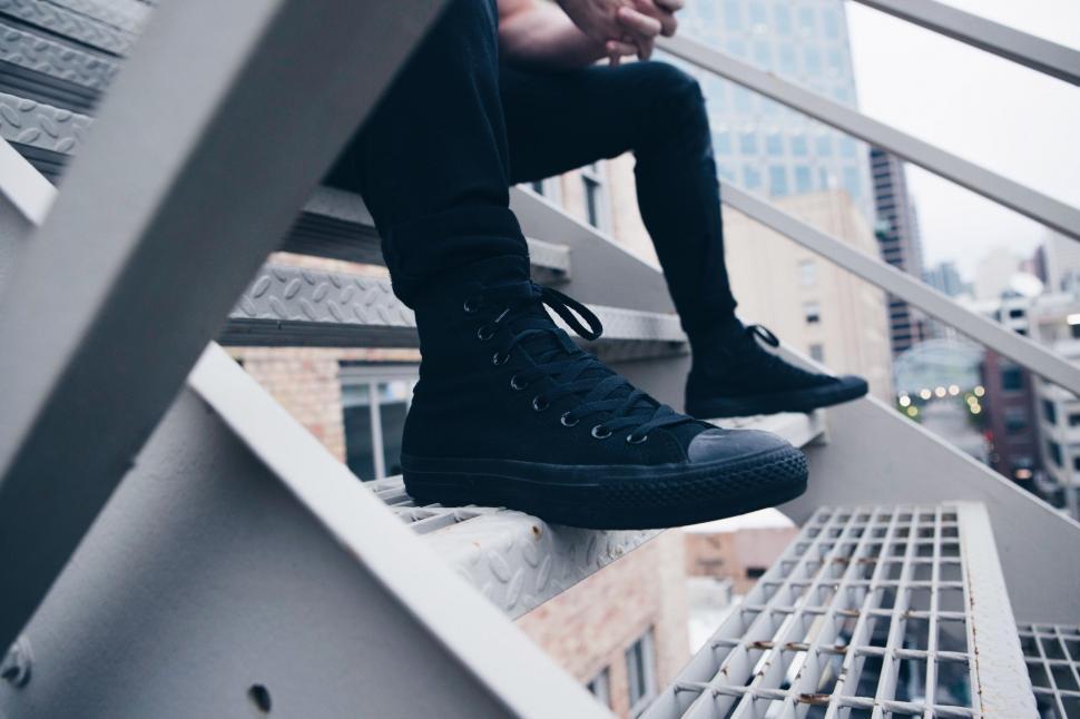 Free Image of Man Sitting on Top of Metal Staircase 