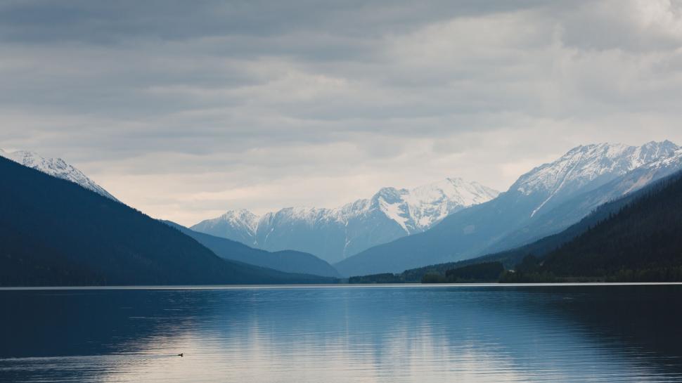 Free Image of Mountainous Terrain Surrounding Body of Water Under Cloudy Sky 