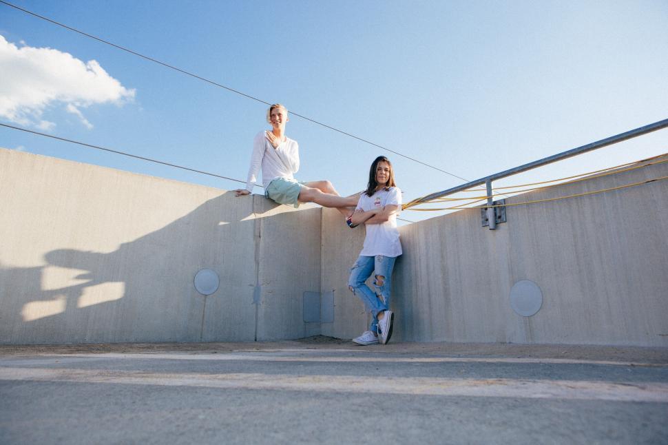 Free Image of Couple Sitting on Wall in Urban Setting 