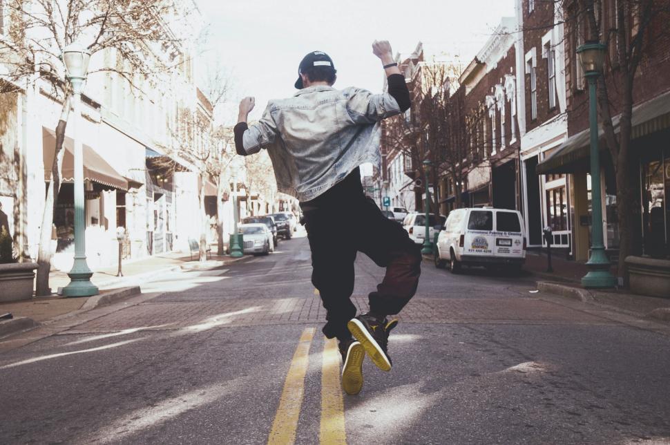 Free Image of Man Riding Skateboard Down Middle of Street 