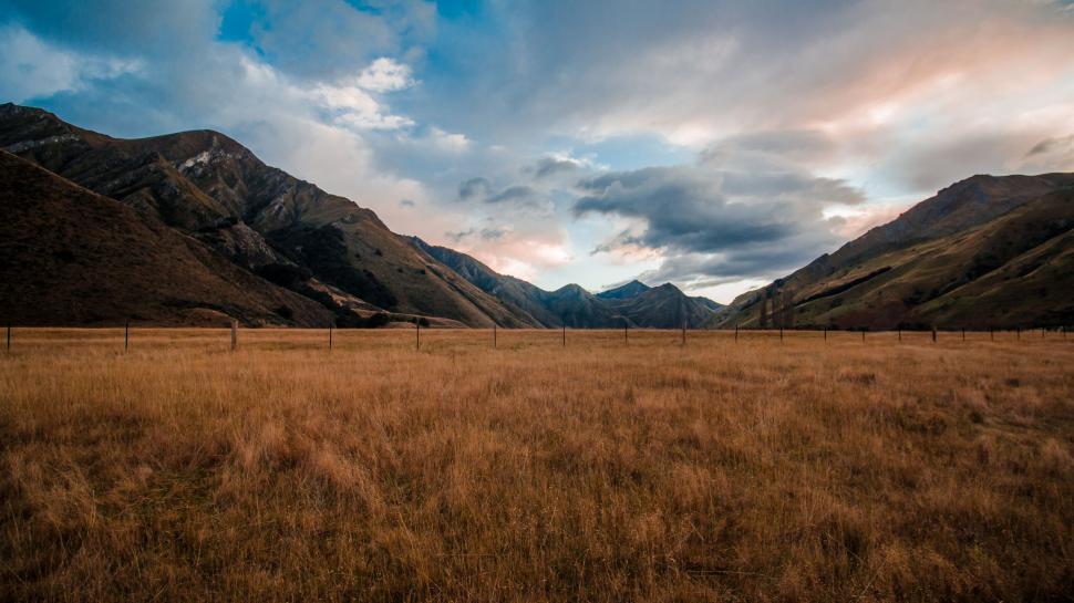 Free Image of Grassy Field With Mountains in Background 