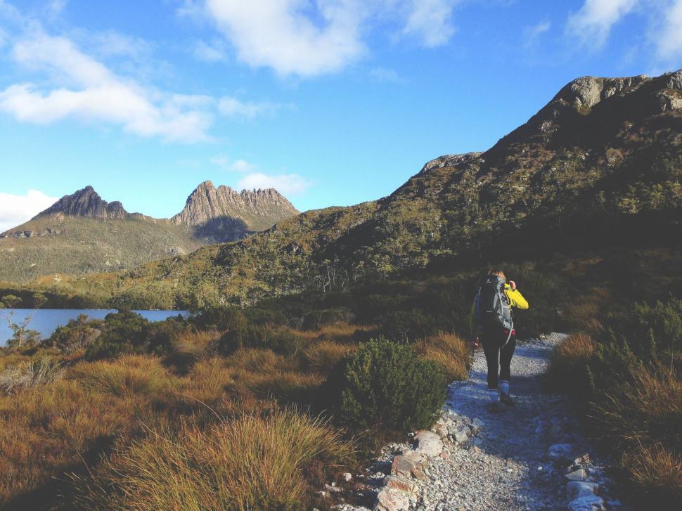 Free Image of Man With Yellow Backpack Hiking Up Trail 