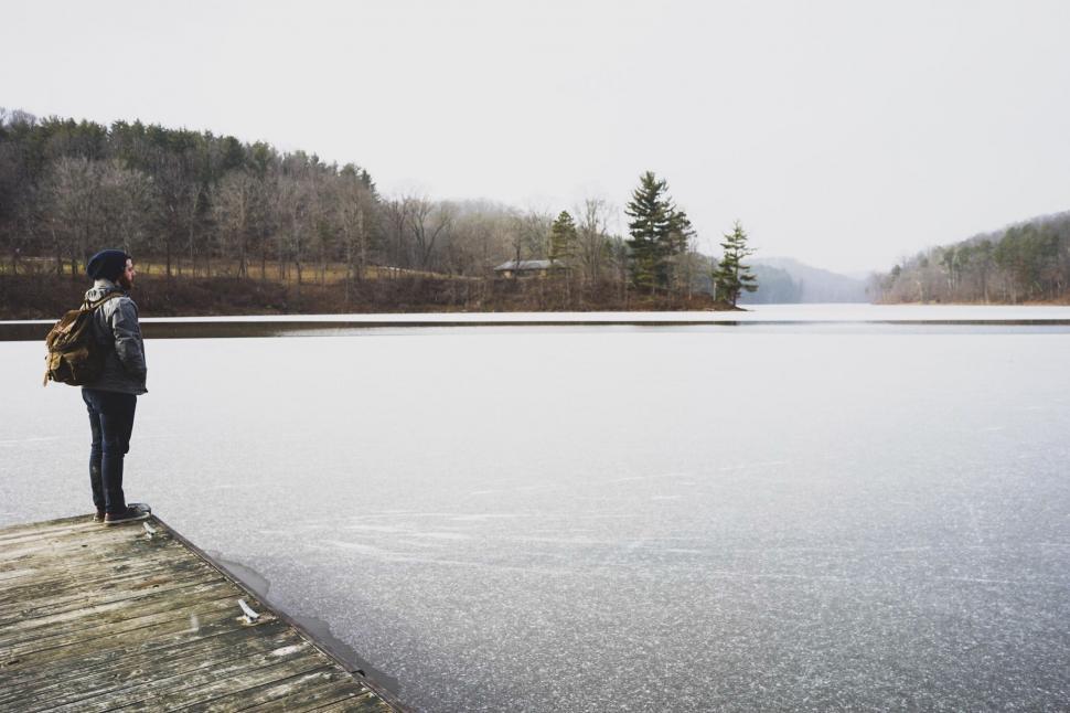 Free Image of Person Standing on Dock Near Body of Water 