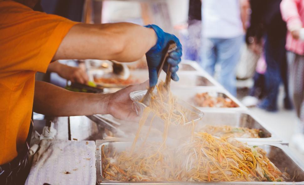 Free Image of Man in Orange Shirt Serving Food 