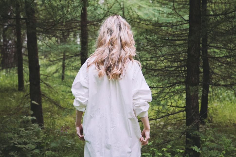 Free Image of Woman in White Dress Walking Through Forest 