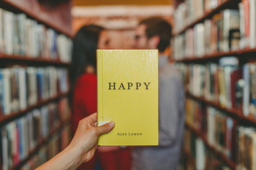 Free Image of Person Holding Yellow Book in Library 