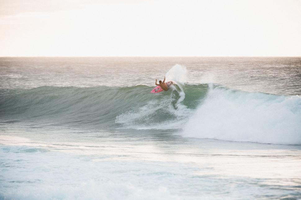 Free Image of Person Riding Wave on Surfboard 