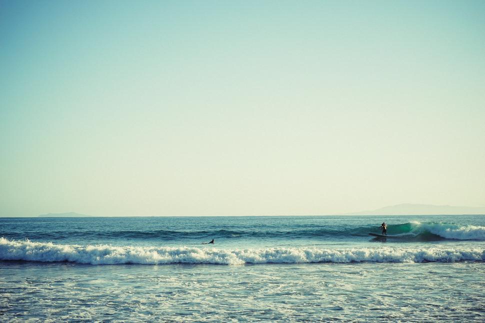 Free Image of Person Riding Surfboard on Ocean Wave 