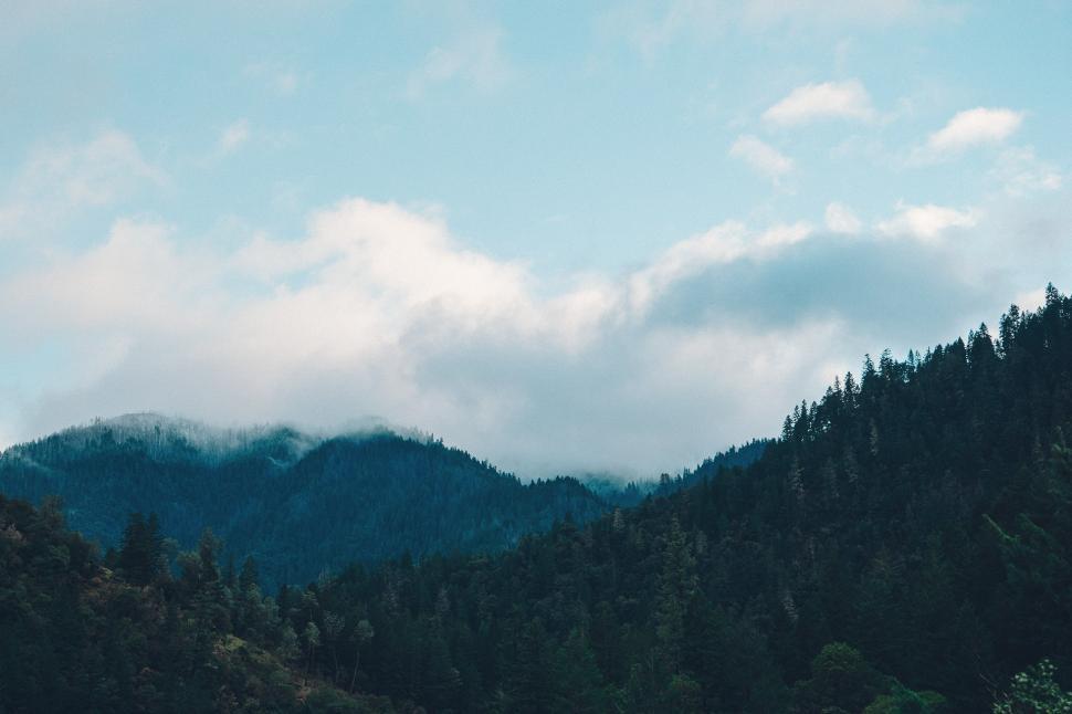 Free Image of Majestic Mountain Range With Trees and Clouds 