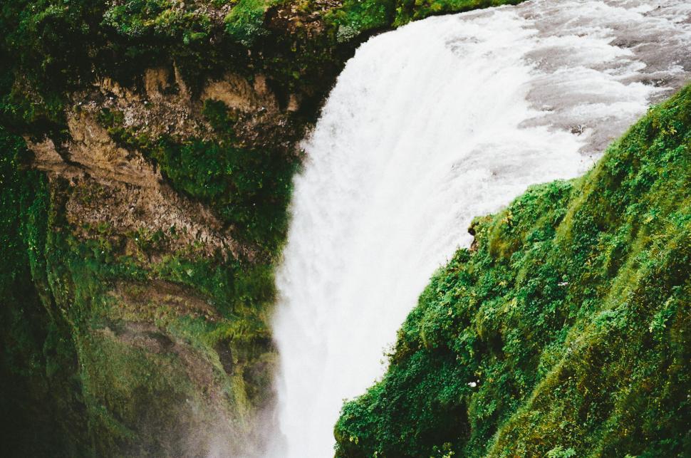 Free Image of Man Standing in Front of Waterfall 