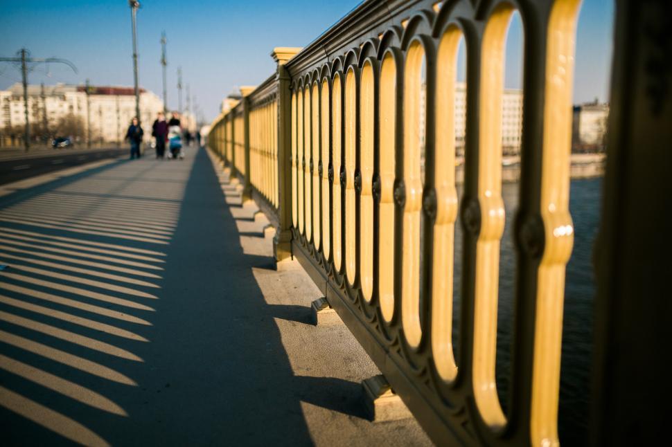 Free Image of People Walking on a Bridge Over a Body of Water 